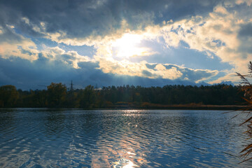 Wide blue lake under the rays of the setting sun