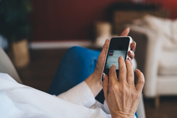 Unrecognizable woman reading text message in smartphone