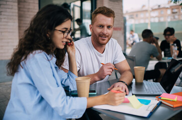 Fototapeta premium Portrait of red haired male It professional looking at camera during collaborative together meeting 