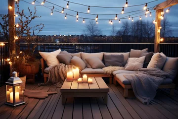 Foto op Canvas Cozy outdoor roof terrace with a sofa and coffee table is decorated with garlands and lamps © colnihko