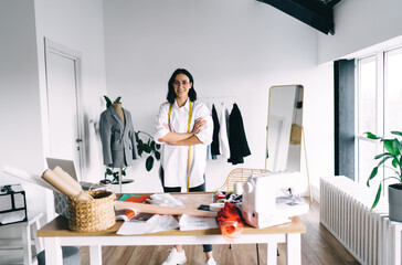 Smiling female seamstress in atelier