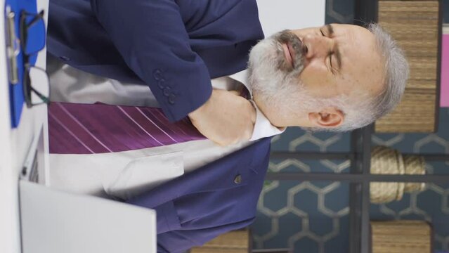 Vertical video of Depressed and constricted old businessman loosening his tie.