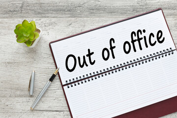 Out of office. text on the page of an open diary.