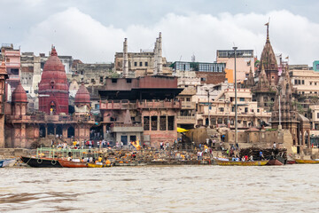 View of the river Ganges with its boats, people and sacred water of Varanasi in India. Manikarnika...