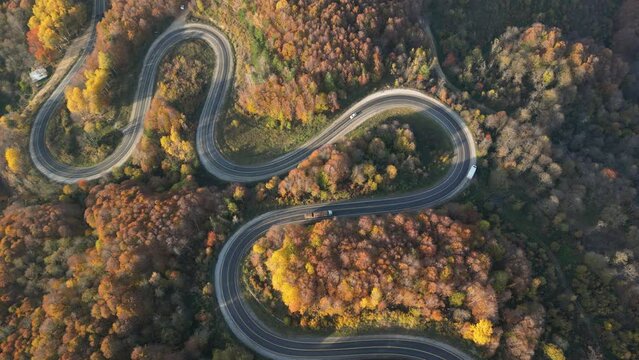 Curvy mountain roads in autumn. Vehicles in motion on winding mountain roads.