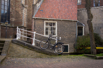 Black bicycle, white handrails and New church on Market square, popular tourist destination, Delft, Netherlands