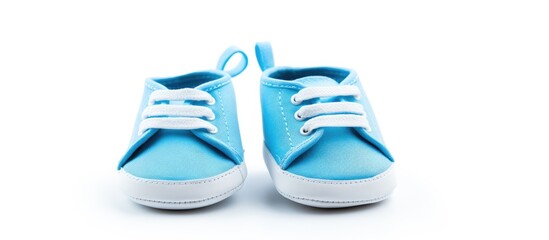 Baby shoes that are blue in color with a white background surrounding them are separated from their surroundings