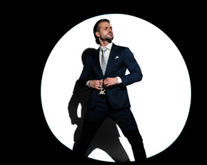 confident high class man looking to side and buttoning suit