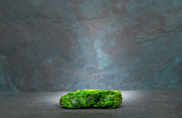 natural green stone on a gray background for the podium