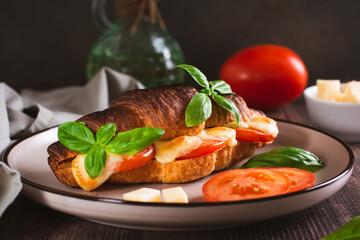 Croissant caprese sandwich baked with tomatoes and cheese on a plate