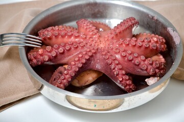 cooking octopus in pot with fork