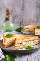 Chopped sandwiches with egg, bacon and herbs salad on a plate on the table vertical view