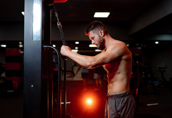 Fototapeta na wymiar A shirtless man working out in a gym. A Strong Athlete Pushing His Limits in the Gym