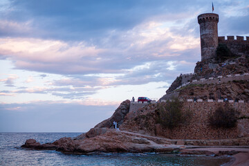 Tossa de mar, castello sulla spiaggia di Tossa e mare che si fondono insieme al tramonto. - obrazy, fototapety, plakaty