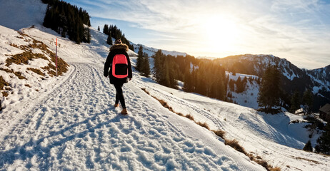 Young woman walking on snow mountain track during winter time at sunset - Travel and landscape...