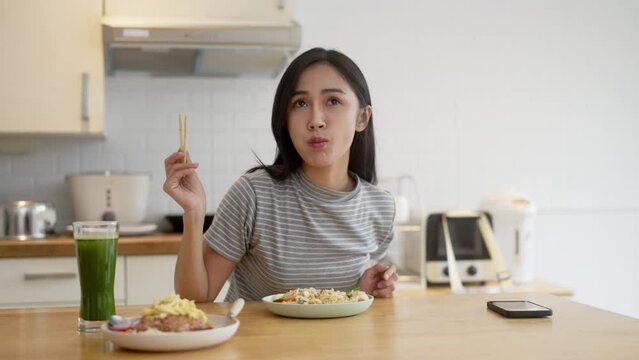 Asian woman eating Local Traditional Shrimp Pad Thai at her home.