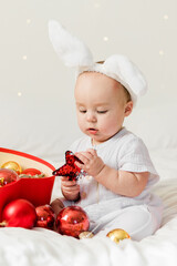 Adorable baby boy playing with Christmas baubles and new year gift. Winter holidays celebration and festive concept