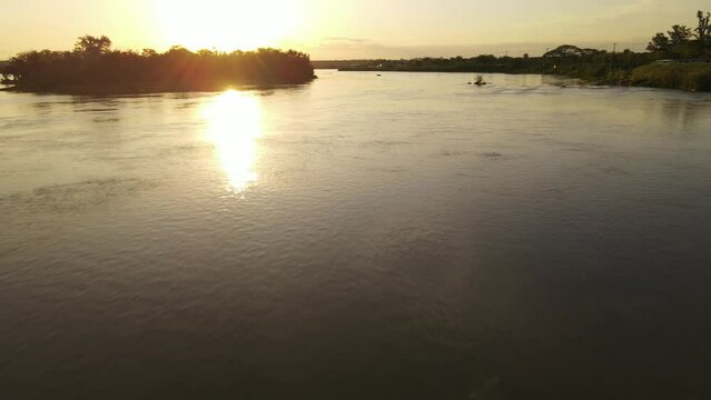 Flight over the river at sunset on the coastal avenue in Termas de Rio Hondo, Santiago del Estero, Argentina