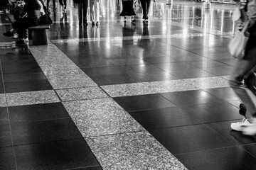 光を反射してキラキラ光る道を歩く人。jr大阪駅構内で撮影 - obrazy, fototapety, plakaty