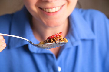 Healthy breakfast concept. Woman eats granola with fruit.