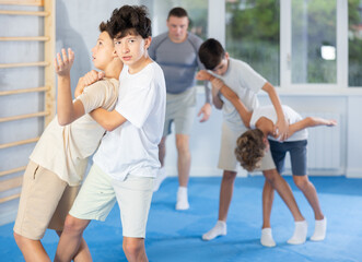 Sedulous underage practitioner of self-defense courses applying attack methods on his opponent