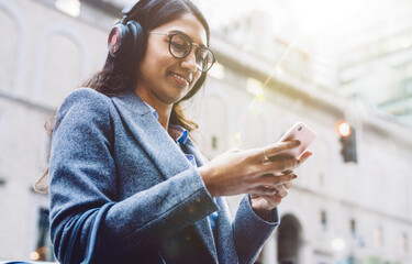 Young woman enjoying playlist in earphones