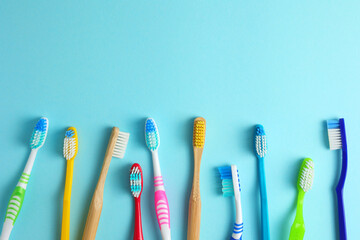 Different toothbrushes on a colored background. Dental care, oral health. - obrazy, fototapety, plakaty