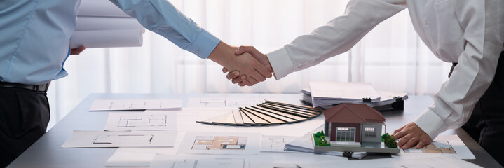 Interior designer shake hand with client or colleagues after made successful sketching and choosing...