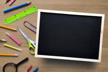 Template with copy space. School or business theme. Flat lay. Blank Chalkboard on background of desk with stationery. Place for text.