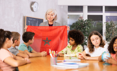 listening to teacher s story about Morocco, girl examines this country on globe