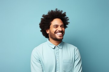 happy african american man with afro hairstyle on blue background