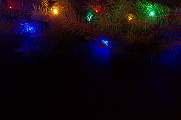 Fototapeta na wymiar A Christmas tree, decorations, lights on a black background. Top view.