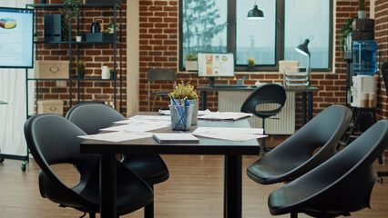 Empty boardroom meeting table with files, executive management project on papers in business office. Global agency coworking space with workstations and briefing documents for development.
