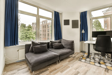 Obraz premium a living room with wood flooring and blue drapes hanging on the windows in the room is very spacious