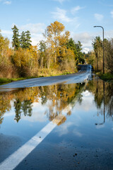 After the storm, rainwater flooding over a residential street on a sunny fall day
