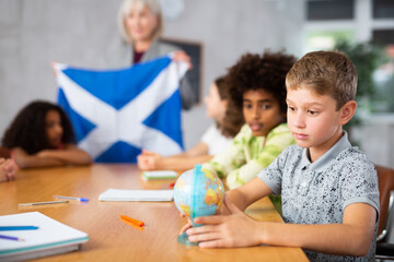in geography lesson, elderly teacher very eloquently tells children about history of ancient scotland