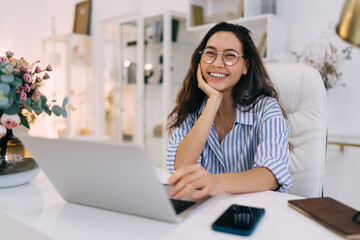 Smiling woman with laptop in modern room