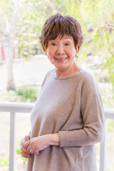 Fototapeta premium Happy Senior Chinese Woman Poses for Her Portrait Outdoors.