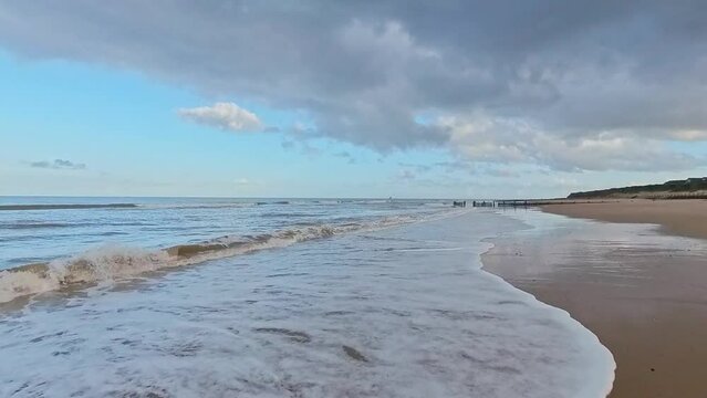 Grey clouds build in blue skies over the North Norfolk coast. Captured in the seaside village of Walcott and Ostend in the autumn