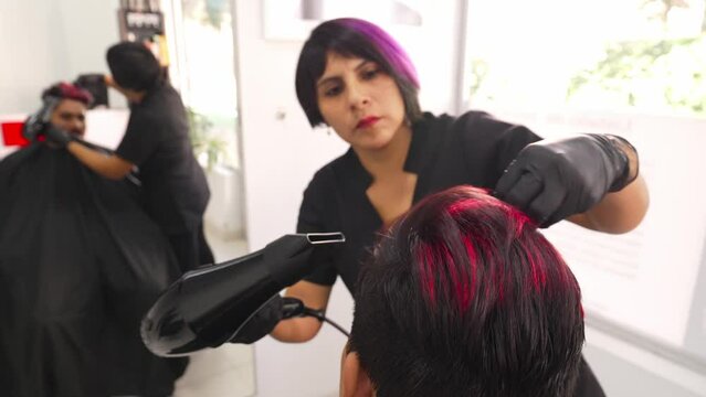 Professional hairdresser hairstyling customer's hair, combing and molding it while colour ink is applied on his beard_5.MOV