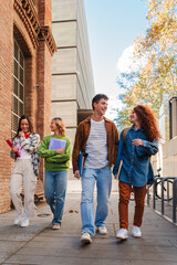 Vertical. Group of smiling high school teenage students walking before starting class, talking together. Diverse classmates carrying notebooks and backpacks going along university. Academy people © Jose Calsina