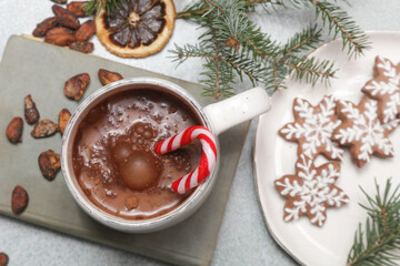 Cozy winter lifestyle concept. Mug of hot drink with vintage book and tasty homemade Christmas gingerbread cookies.