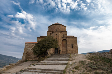 Fototapeta na wymiar Jvari Monastery Georgian Orthodox with city Mtskheta and clouds on blue sky