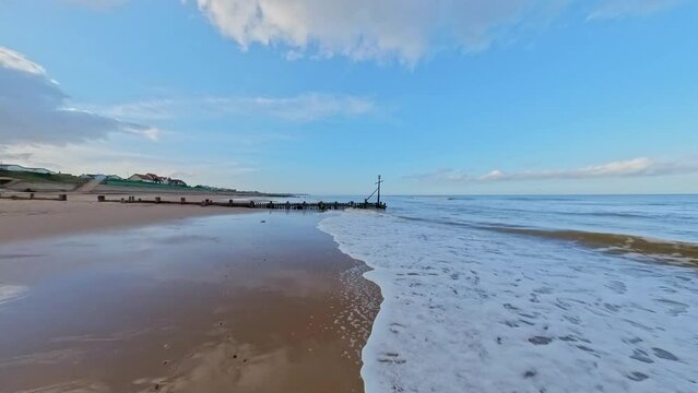 Afternoon on the coast as the tide rolls in - pull back shot. Captured in the seaside village of Walcott and Ostend in the autumn