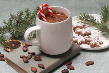 Cozy winter lifestyle concept. Mug of hot drink with vintage book and tasty homemade Christmas gingerbread cookies.