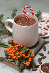 Cozy winter lifestyle concept. Mug of hot drink with vintage book and tasty homemade Christmas gingerbread cookies.