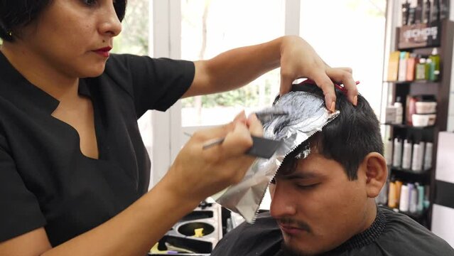 Professional Stylist dyeing customer's hair in hairdressing salon. Process of hair coloring_6.MOV