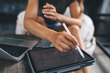 Unrecognizable woman drawing with stylus on tablet