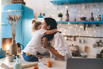 Mother and daughter hugging in kitchen