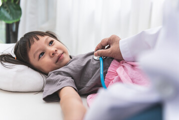The doctor is using a stethoscope Listen to heart rate of a 3-year-old girl patient which lying on...